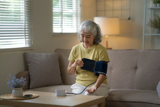 Female senior monitoring blood pressure at home