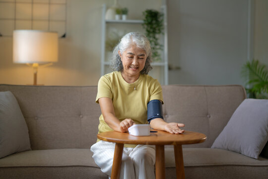 Senior woman monitoring health with blood pressure device