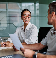 Portrait of young businesswoman and mid aged businessman having a meeting or presentation and...