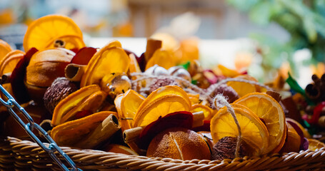 Wicker basket full of Christmas decorations made with dried oranges, lemons and cinnamon sticks
