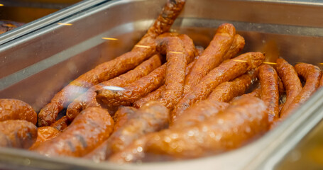 Delicious sausages are on display in a shop window, inviting passersby to explore this tasty source of protein perfect for holiday meals and cooking adventures.