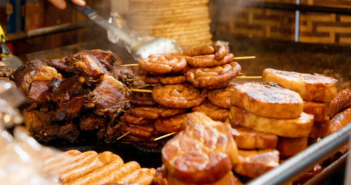 Sausages and various meat cuts are showcased in a shop window, enticing customers with delicious options for holiday cooking and gatherings.