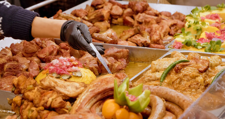 Delicious array of meats and sausages showcased at a vibrant market, enticing customers with savory aromas and festive vibes perfect for holiday cooking.