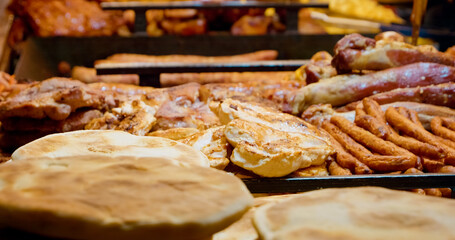 Explore an enticing display of meats, sausages, and other products in a market, showcasing the rich variety available for festive meals and daily cooking.