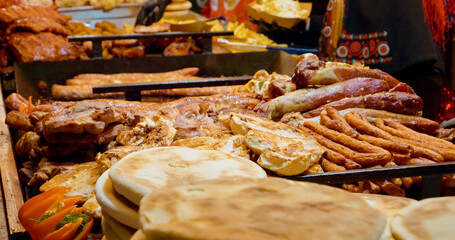 Delicious street food with sausages, grilled meat, flatbreads and vegetables displayed on a food stall