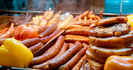 Delicious street food with steaming sausages and a stack of grilled pork, ready to be served