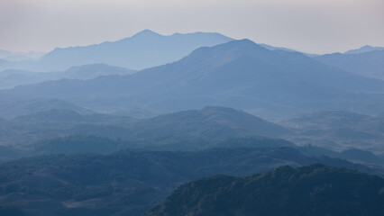 Obraz premium Silhouettes of forested mountain ridges disappearing in morning haze, Durmitor, Montenegro