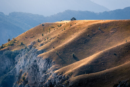 Mountains landscape with house on hilltop beautifully illuminated by setting sun, Durmitor, Montenegro