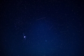 Starry night sky with shooting stars and constellations