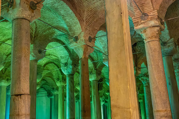 Ancient underground basilica cistern with illuminated columns and brick arches
