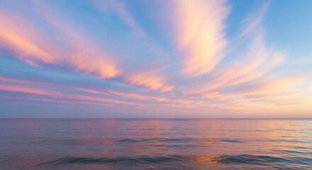 Fototapeta premium Serene seascape with pink-peach clouds reflected in the calm, pastel-colored water. The image evokes peace, tranquility, and the beauty of nature