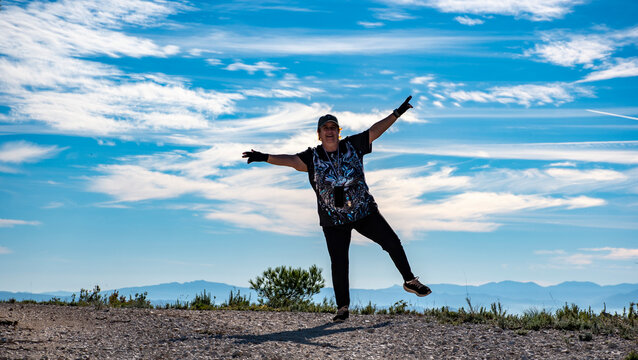 fotos panor&aacute;micas, paisajes de monta&ntilde;a con un cielo azul intenso y nubes blancas, con una mujer alegre saludando