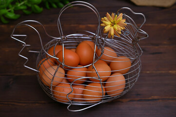 homemade eggs in a chicken shaped basket on a dark wooden background