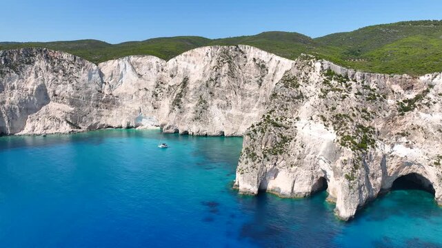 Aerial drone cinematic video of famous caves of Agalas a popular yacht and sail boat place with white steep volcanic rocks and turquoise crystal clear sea, Zakynthos island, Ionian, Greece