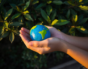 World in Our Hands: A close-up shot of hands tenderly cradling a miniature globe, with the earth carefully crafted. Reflecting themes of environmental responsibility.
