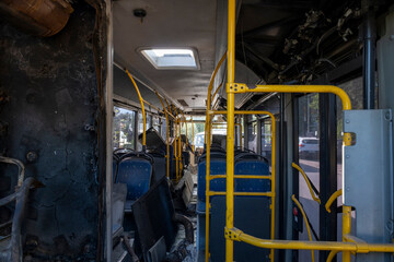 Interior of a scrapped city bus. Worn out public bus interior in scrap yard. Abandoned public transport bus interior.