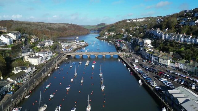 Looe, Cornwall, England: DRONE VIEWS: The drone flies over the town of Looe towards the East Looe river and Looe Bridge. Looe is an ancient fishing port and popular UK holiday destination.