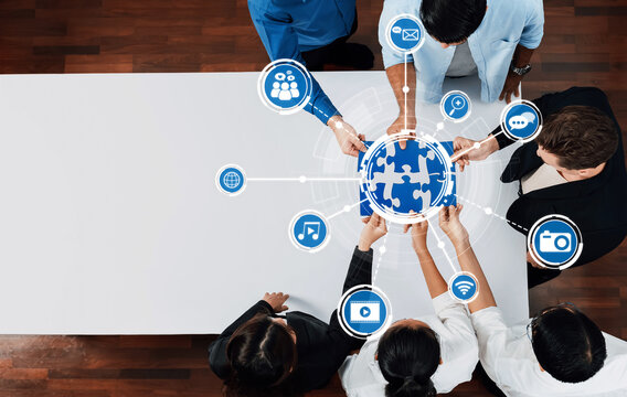 A diverse group of professionals engages over a puzzle globe, symbolizing collaboration and connections in the digital world. Icons highlight technology and communication themes. Amity