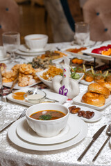 Elegant soup bowl with fresh herbs on white plate at lavish breakfast buffet