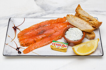 Saumon gravlax servi avec beurre et baguette, plat de bistro français