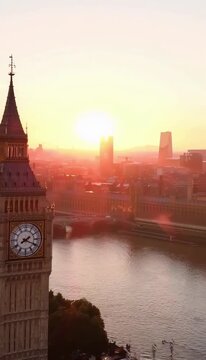 Big Ben clock tower and the River Thames in London at a beautiful sunset with an orange sky and city skyline.
