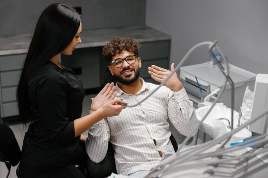 Dentist and patient smiling in dental clinic for check-up
