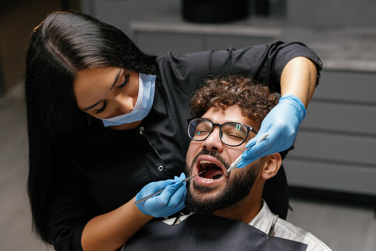 Dentist checking patient teeth during oral examination