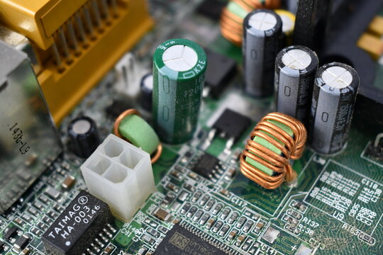 Motherboard closeup. TAIMAG, ICS, branding. Complex circuits with capacitors chips and plugs.