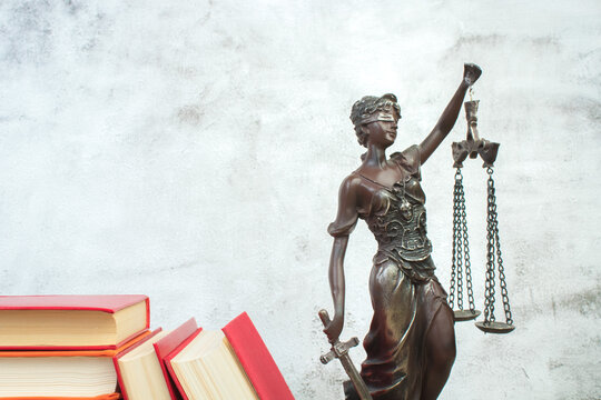 Law concept - Open law book, scales, Themis statue on table in a courtroom or law enforcement office. - Powered by Adobe