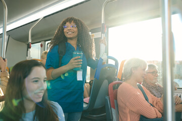 Young nurse commuting by public transport smiling on bus