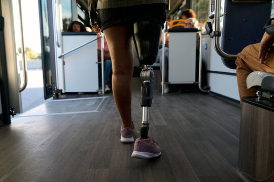 Woman with prosthetic leg walking inside public bus