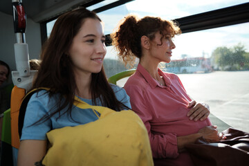 Pregnant woman and daughter traveling by bus