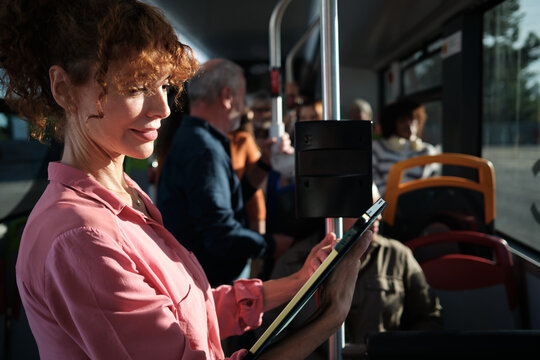 Woman commuting on bus reading digital tablet - Powered by Adobe