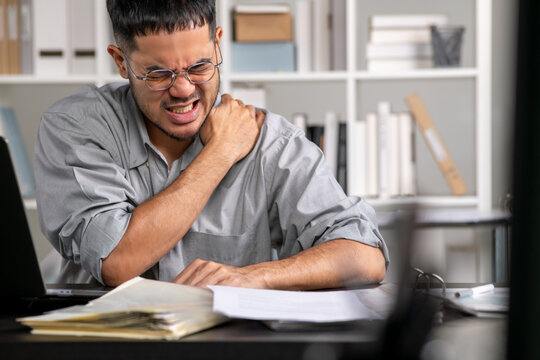 Businessman having neck ache and shoulder pain from working in the office