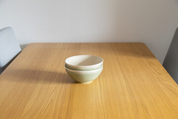 Minimal stack of bowls centered on table. Order, lightness, and quiet aesthetic of Scandinavian home. Copy space