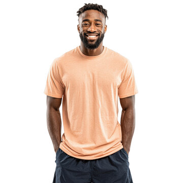Smiling African American man in a peach t-shirt standing with hands in pockets isolated on white for lifestyle or fashion concepts