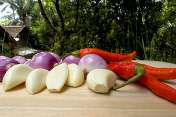 Fresh Ingredients on Wooden Board - Garlic, Onions, and Red Chilies.