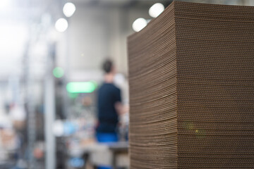 Stack of corrugated cardboard sheets in industrial packaging facility