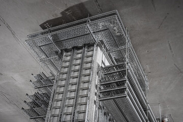 Multi-level metal cable trays suspended under concrete ceiling in industrial building