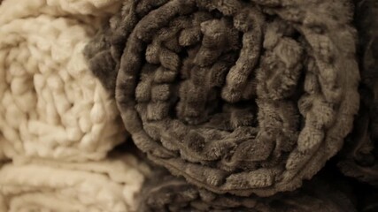 Rolled fluffy cozy and soft plush blankets. Modern aesthetic comfortable living room or bedroom home decor. Snuggly bedding covers. Store shelves merchandise display.