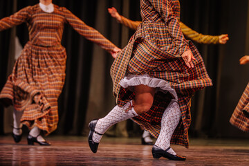 Latvian folk dancers in traditional attire showcase vibrant movements on stage, capturing the essence of cultural heritage and celebration