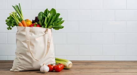 Reusable canvas grocery bag overflowing with fresh organic vegetables on wooden table against white subway tile background. Healthy eating and sustainable lifestyle banner with copy space