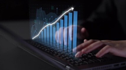 A close-up of hands typing on a laptop, featuring a digital financial graph overlay that illustrates business growth and data analytics in a modern workspace. Copula - Powered by Adobe