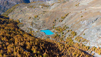 A drone view above Zermatt reveals the stunning Matterhorn region with its famous lakes, golden larches, and a deep blue autumn sky in perfect harmony.