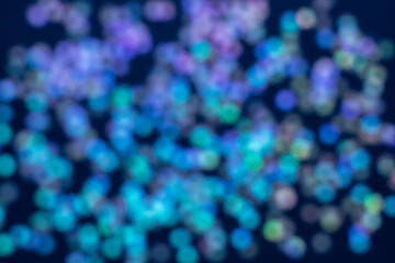 Abstract bokeh lights in blue, green, and purple tones creating a vibrant festive ambiance