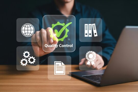 Person interacting with quality control icons on a screen near a laptop on a wooden surface