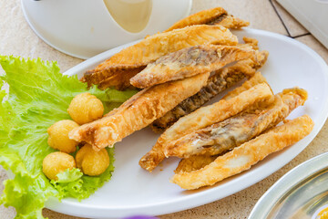 Crispy Fried Fish with Lettuce and Side Balls on White Plate