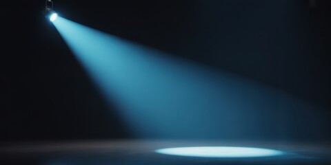 A single blue spotlight illuminating a dark stage with a beam of light shining down from above