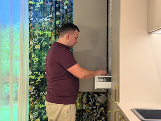 Man using kitchen appliance in modern home