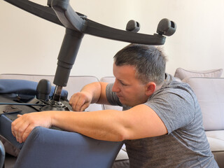 Man repairing an office chair in a living room